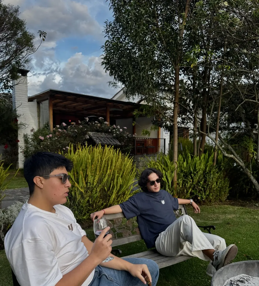 Two friends in a garden in Ecuador, wearing drop 01 tees.